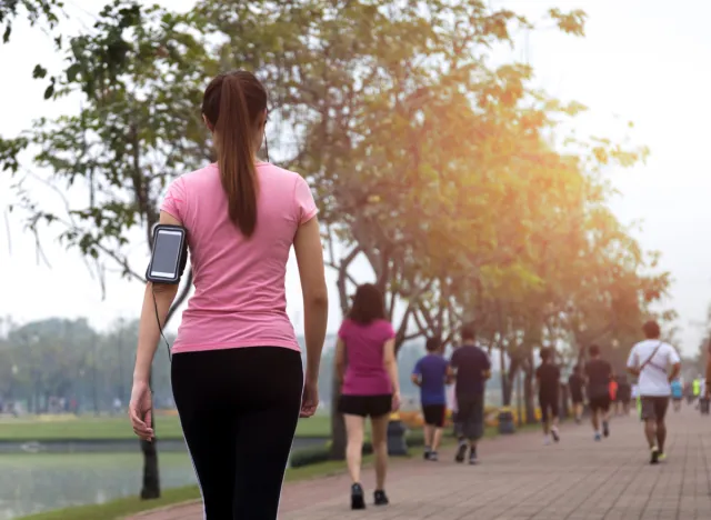 woman walking on sidewalk for exercise, concept of benefits of walking after meal