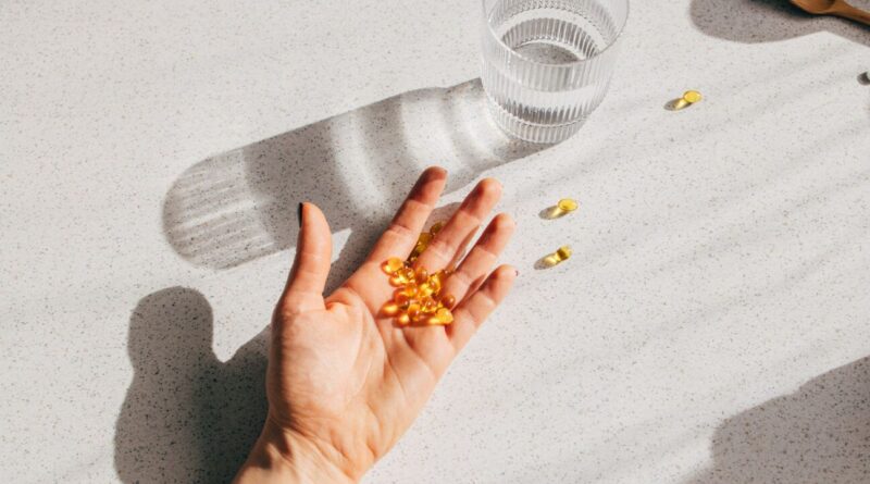 Vitamin D capsules in human hand.